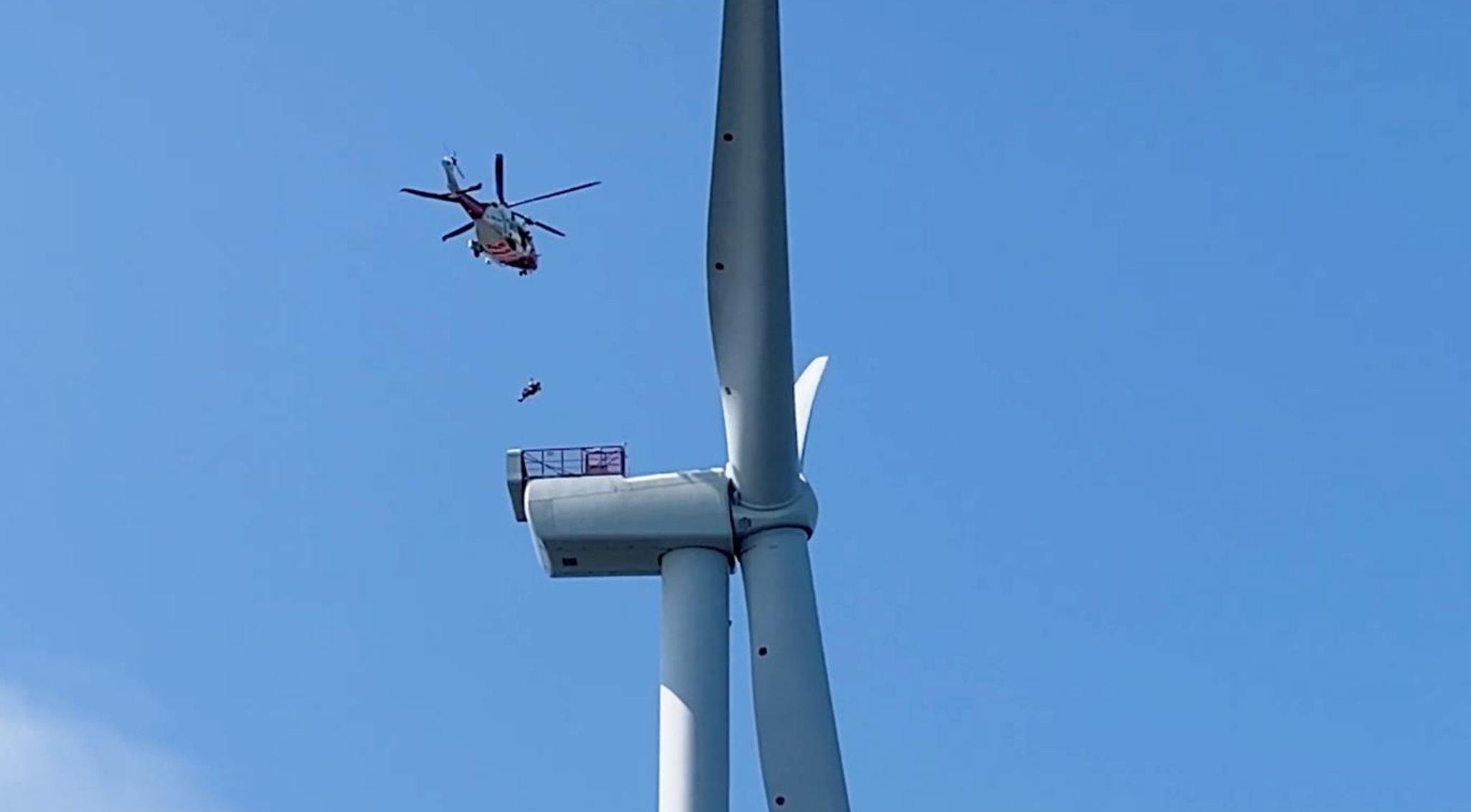 Coastguard helicopter lifting worker